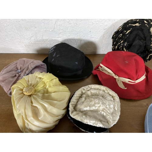 501 - A large collection of vintage hats to include early to mid 20th century black felt bowler hat, fur h... 