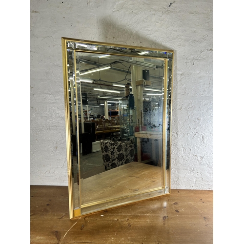 235 - A modern gilt and bevelled glass framed bevelled edge wall mirror - approx. 74cm high x 104cm wide