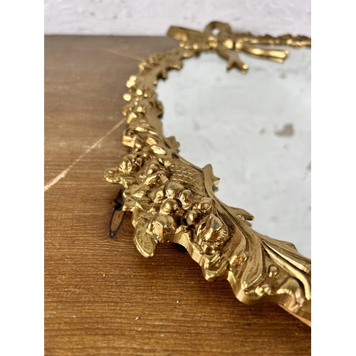 252 - A 20th century gilt metal framed wall mirror with bow design - approx. 56cm high x 47cm wide