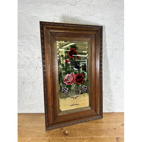 281 - An early 20th century carved oak framed bevelled edge reverse glass painted wall mirror with floral ... 