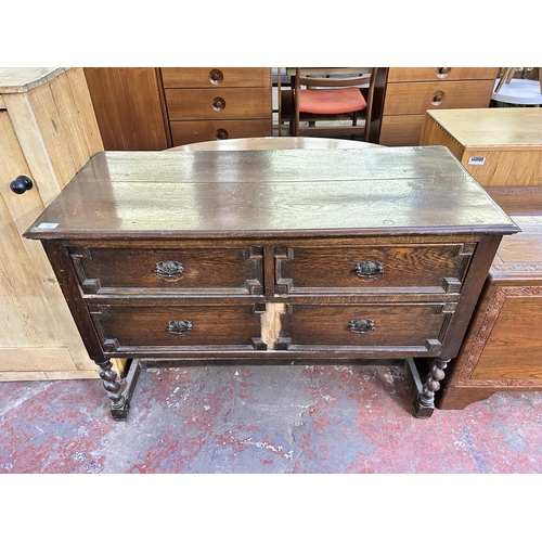129 - An early 20th century Jacobean style geometric carved oak chest of drawers on barley twist supports ... 