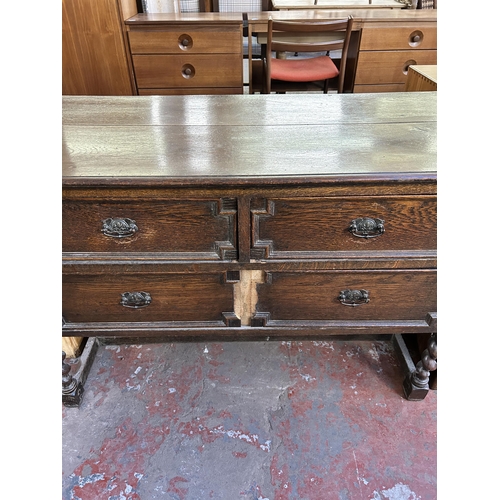 129 - An early 20th century Jacobean style geometric carved oak chest of drawers on barley twist supports ... 