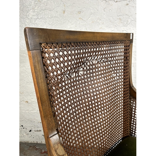135 - A mid 20th century beech and rattan bergère chair on barley twist supports