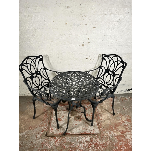 136 - A Victorian style wrought metal three piece patio set comprising two armchairs and circular table - ... 