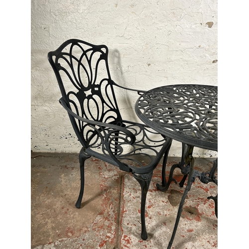 136 - A Victorian style wrought metal three piece patio set comprising two armchairs and circular table - ... 