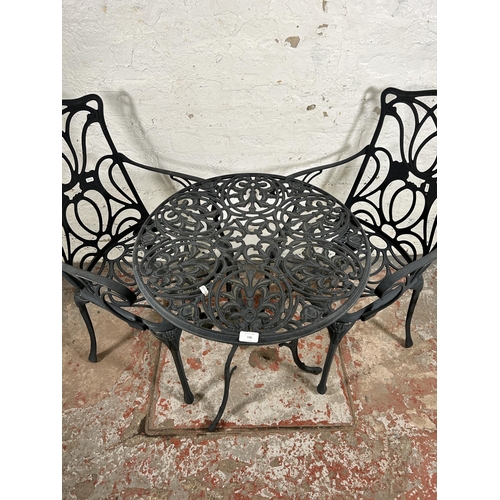 136 - A Victorian style wrought metal three piece patio set comprising two armchairs and circular table - ... 