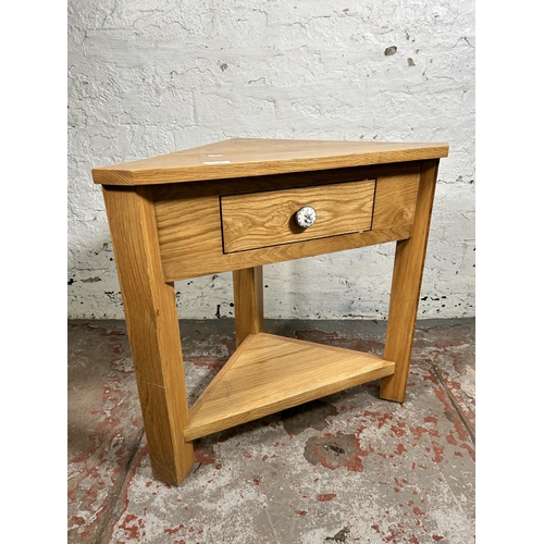 154 - A modern solid oak single drawer corner occasional table - approx. 60cm high x 65cm wide x 38cm deep