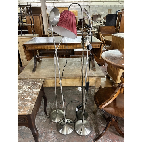 171 - Four floor lamps, three brushed steel and one brass effect