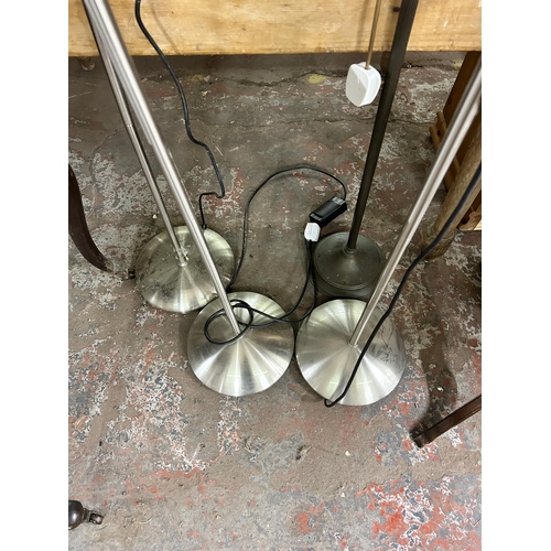 171 - Four floor lamps, three brushed steel and one brass effect