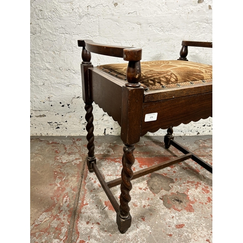 173 - An early/mid 20th century oak and fabric upholstered barley twist piano stool