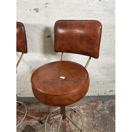 56 - A pair of mid 20th century brown vinyl and tubular metal swivel bar stools - approx. 94cm high