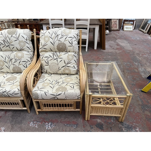 69 - A wicker and cane four piece conservatory suite comprising glass top rectangular coffee table, two c... 