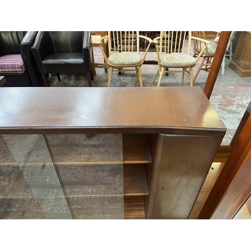 75 - A mid 20th century Nathan oak veneer bookcase with two glass sliding doors - approx. 93cm high x 122... 