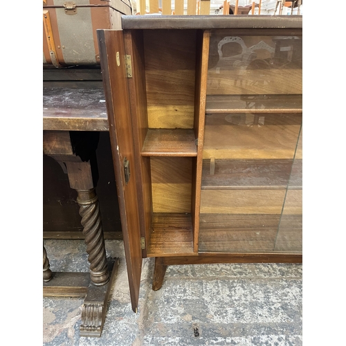 75 - A mid 20th century Nathan oak veneer bookcase with two glass sliding doors - approx. 93cm high x 122... 