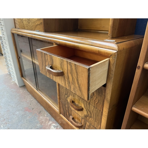 91 - An Art Deco walnut drinks cabinet with two glass sliding doors and fall front - approx. 106cm high x... 