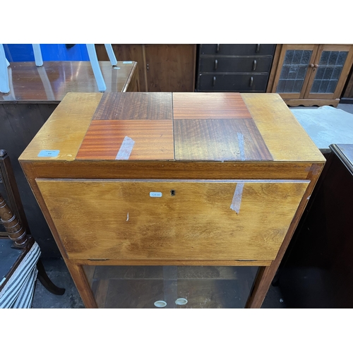 93 - A mid 20th century plywood bureau bookcase with glass sliding doors