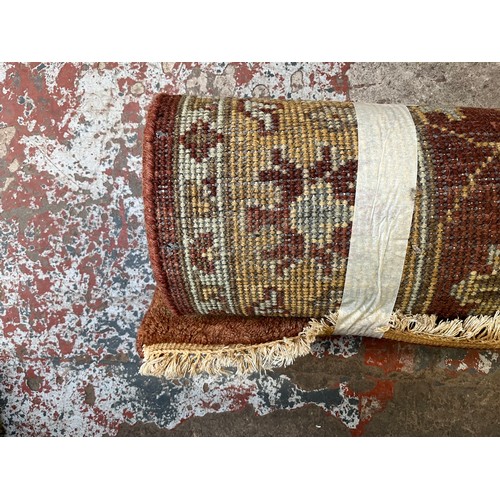 53 - A modern red and beige floral pattern machine woven rug - approx. 6'1