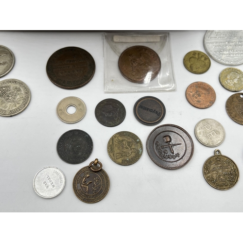 2208 - A collection of tokens and world coins with silver examples to include 50% 1903 Russian twenty kopec... 