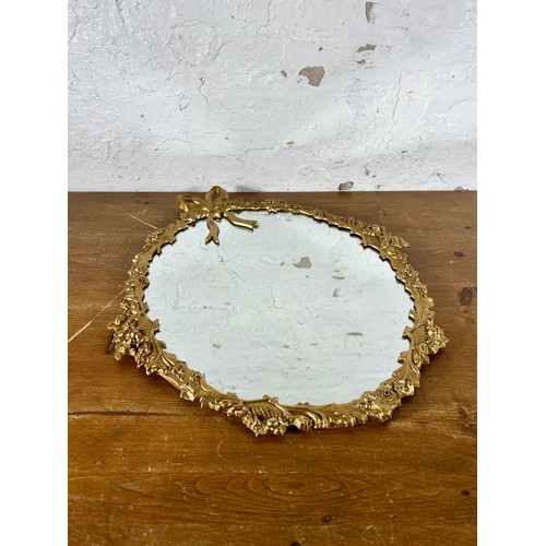 252 - A 20th century gilt metal framed wall mirror with bow design - approx. 56cm high x 47cm wide