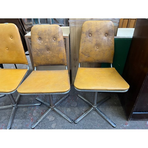 29 - Four 1960s mustard yellow vinyl and chrome plated swivel dining chairs