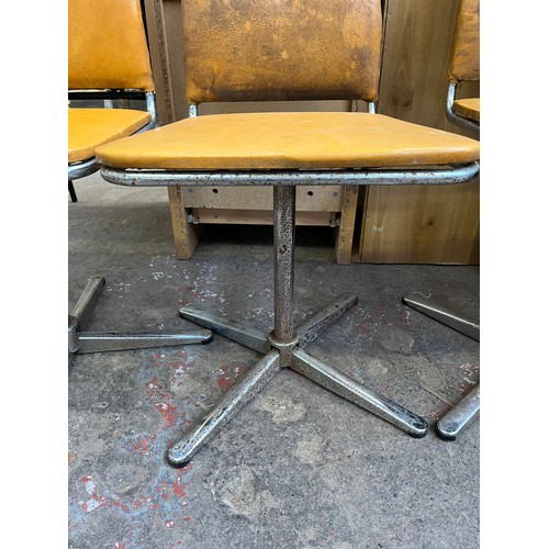 29 - Four 1960s mustard yellow vinyl and chrome plated swivel dining chairs