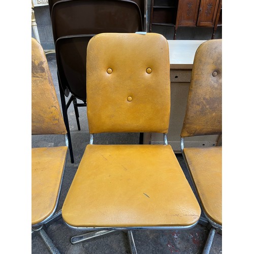 29 - Four 1960s mustard yellow vinyl and chrome plated swivel dining chairs