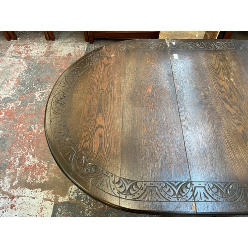 186 - A mid 20th century carved oak drop leaf gate leg dining table - approx. 75cm high x 91cm wide x 153c... 