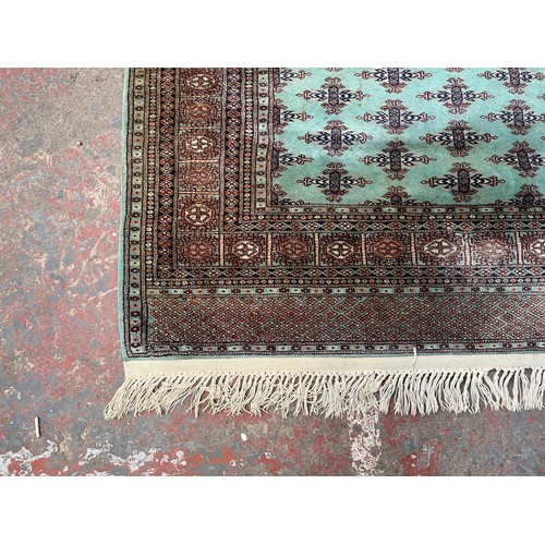 211 - A late 20th century Bokhara turquoise machine woven rug - approx. 193cm x 129cm