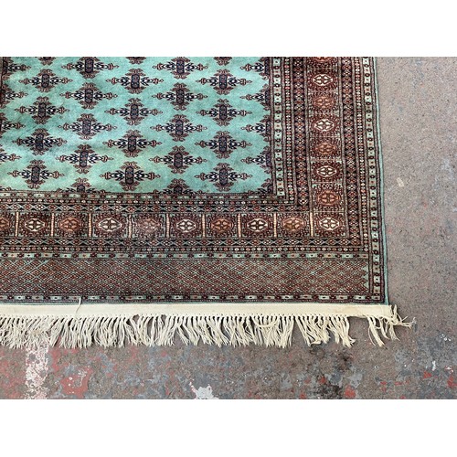 211 - A late 20th century Bokhara turquoise machine woven rug - approx. 193cm x 129cm