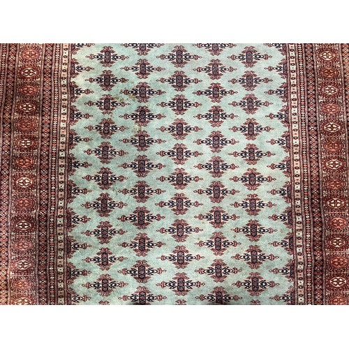 211 - A late 20th century Bokhara turquoise machine woven rug - approx. 193cm x 129cm