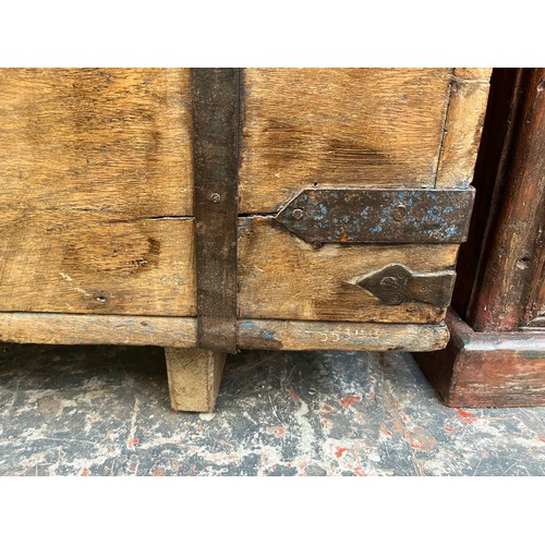 214 - A 19th century teak and metal banded marriage chest - approx. 57cm high x 104cm wide x 48cm deep