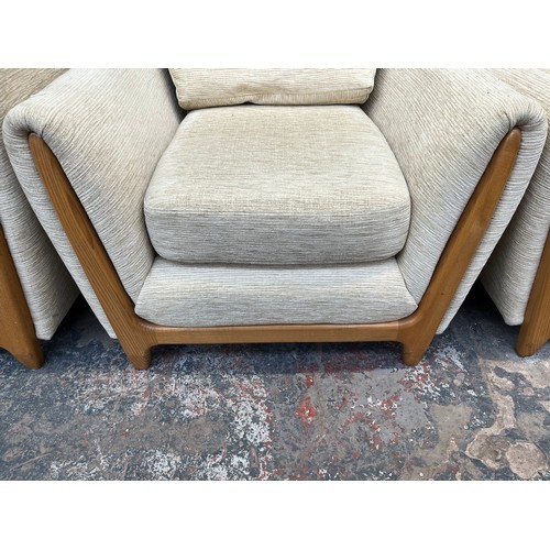 223 - An Ercol beige fabric upholstered and blonde elm three piece lounge suite comprising two seater sofa... 