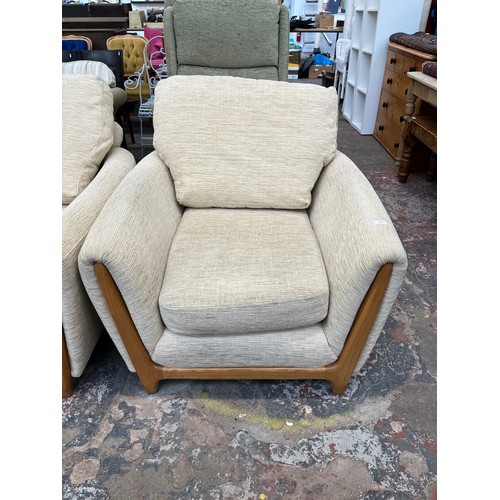 223 - An Ercol beige fabric upholstered and blonde elm three piece lounge suite comprising two seater sofa... 