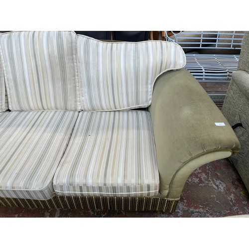 225 - A late 20th century green fabric upholstered and tasselled three seater sofa