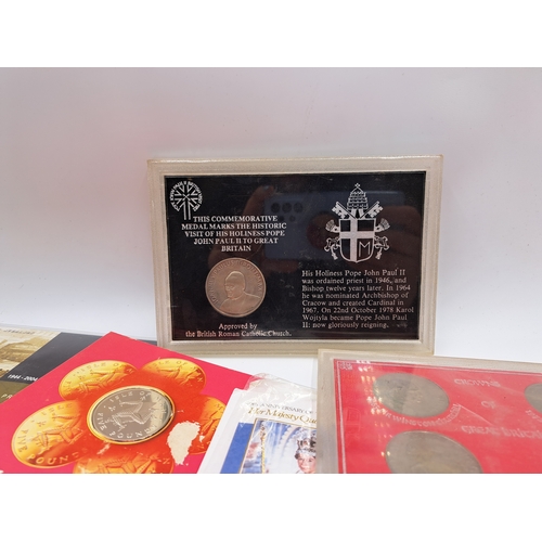 2214 - A collection of commemorative coins and medallions to include packaged 1981 Isle of Man proof £5, 20... 