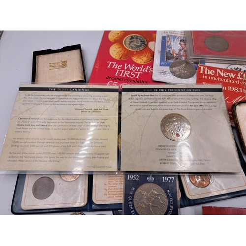 2214 - A collection of commemorative coins and medallions to include packaged 1981 Isle of Man proof £5, 20... 