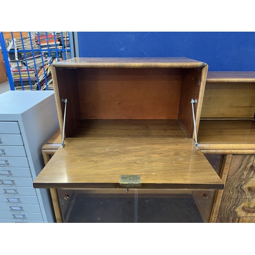 180 - A mid 20th century Art Deco style Rurka walnut drinks cabinet with two glass sliding doors and fall ... 