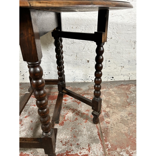 103 - An early 20th century oak drop leaf gate leg oval occasional table on bobbin turned supports - appro... 