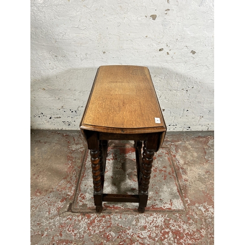 103 - An early 20th century oak drop leaf gate leg oval occasional table on bobbin turned supports - appro... 