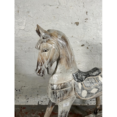 114 - A Victorian style carved hardwood and white painted rocking horse - approx. 97cm high x 28cm wide x ... 