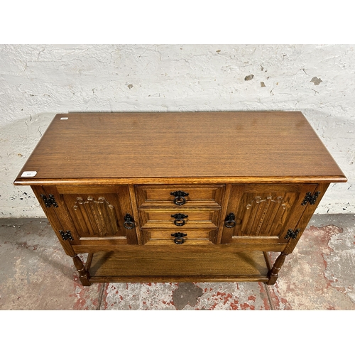 119 - A carved oak linenfold side cabinet - approx. 68cm high x 92cm wide x 37cm deep