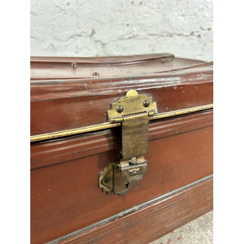 131 - An early 20th century red painted and brass bound travel trunk - approx. 39cm high x 70cm wide x 45c... 