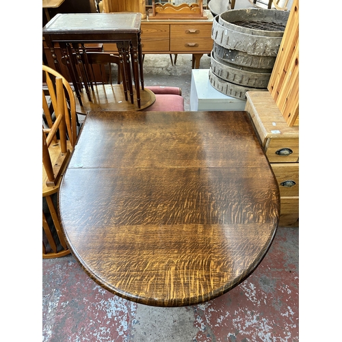 141 - A mid 20th century oak drop leaf gate leg oval dining table