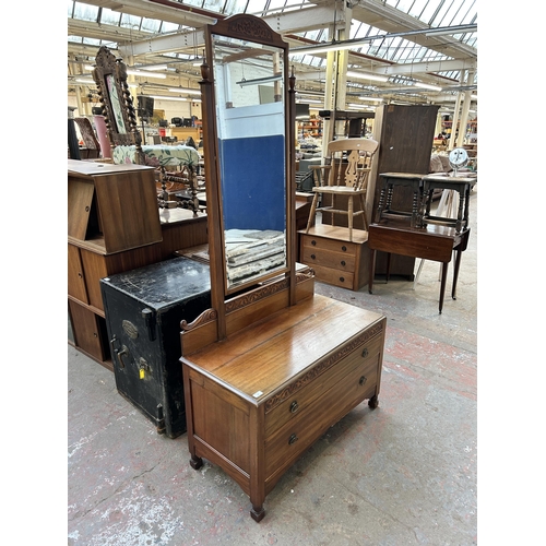 147 - An Edwardian carved mahogany dressing table with bevelled edge mirror and two drawers - approx. 183c... 