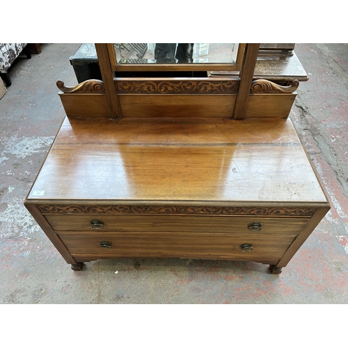 147 - An Edwardian carved mahogany dressing table with bevelled edge mirror and two drawers - approx. 183c... 