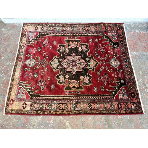 151C - A Persian hand knotted rug with signature - approx. 190cm x 166cm