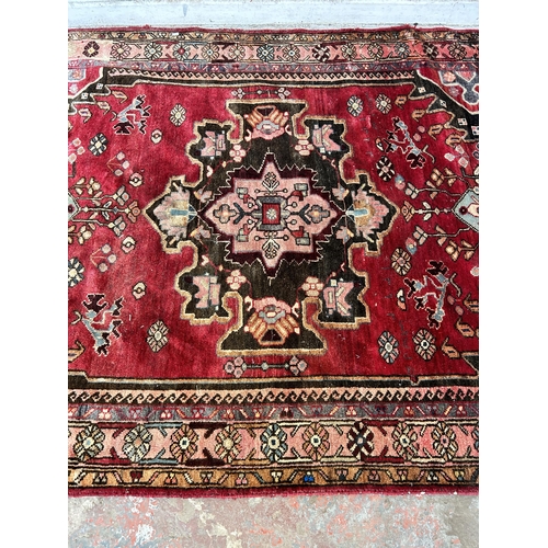 151C - A Persian hand knotted rug with signature - approx. 190cm x 166cm