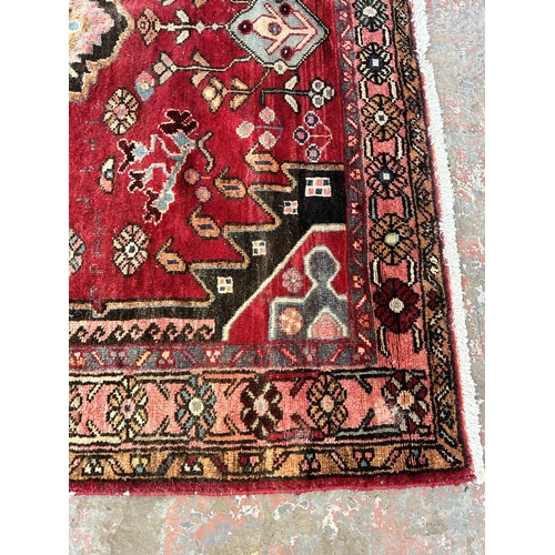 151C - A Persian hand knotted rug with signature - approx. 190cm x 166cm