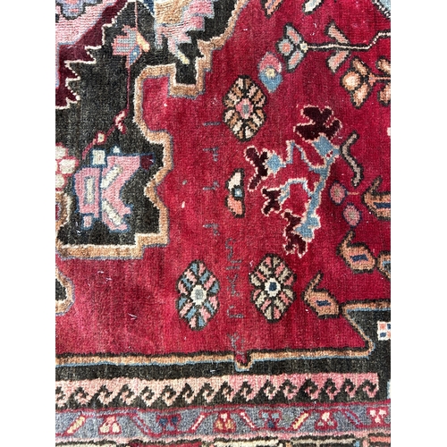 151C - A Persian hand knotted rug with signature - approx. 190cm x 166cm