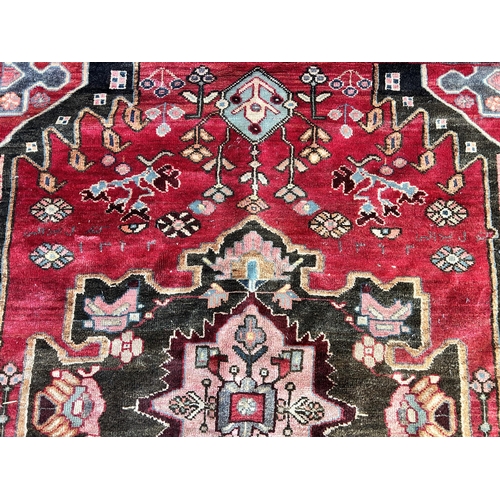 151C - A Persian hand knotted rug with signature - approx. 190cm x 166cm